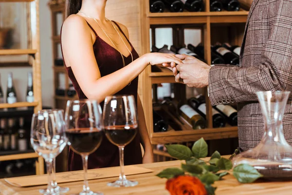 Cropped shot of elegant couple having date at wine storage and holding hands — Stock Photo