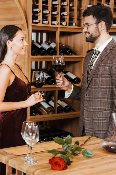 Belo casal elegante brindar com copos de vinho no armazenamento de vinho — Fotografia de Stock