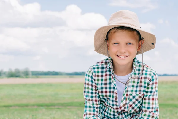 Adorable enfant en chapeau panama souriant à la caméra à la ferme — Photo de stock