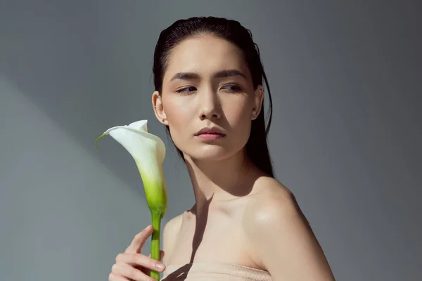 Atraente nu ásia menina com calla flor, isolado no cinza — Fotografia de Stock