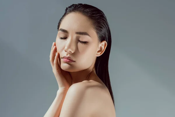 Красива ніжна азіатська дівчина з закритими очима, ізольована на сірому — стокове фото