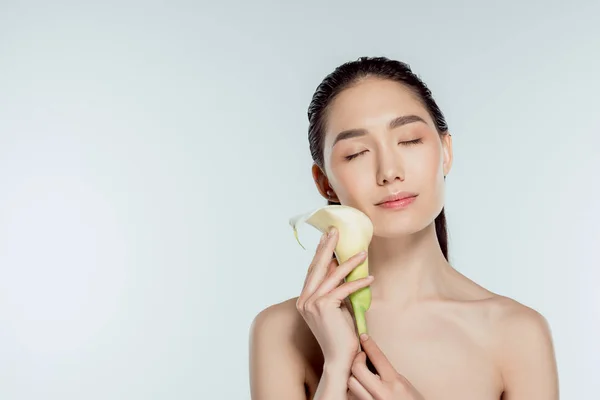 Schöne asiatische Mädchen mit geschlossenen Augen mit Calla-Blume, isoliert auf grau, natürliche Schönheit — Stockfoto