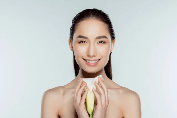 Happy attractive asian girl with calla flower, isolated on grey — Stock Photo
