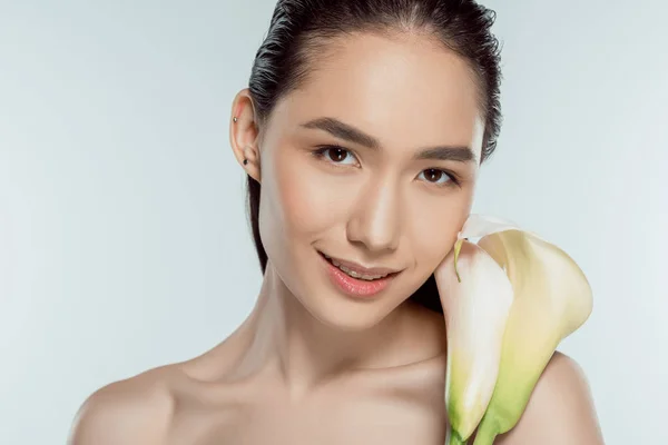 Bella sorridente ragazza asiatica con fiore di calla, isolato su grigio — Foto stock