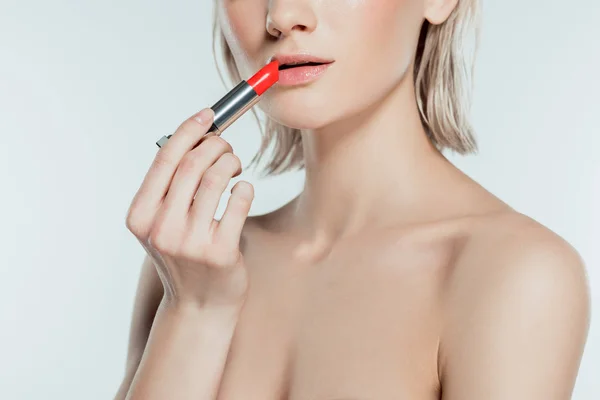 Hermosa mujer aplicando lápiz labial rojo, aislado en gris - foto de stock