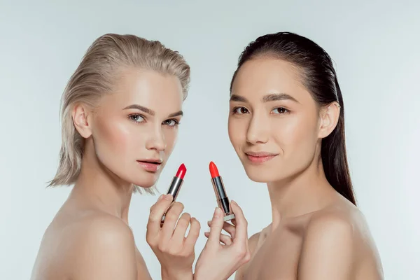 Schöne multiethnische Frauen posieren mit roten Lippenstiften, isoliert auf grau — Stockfoto