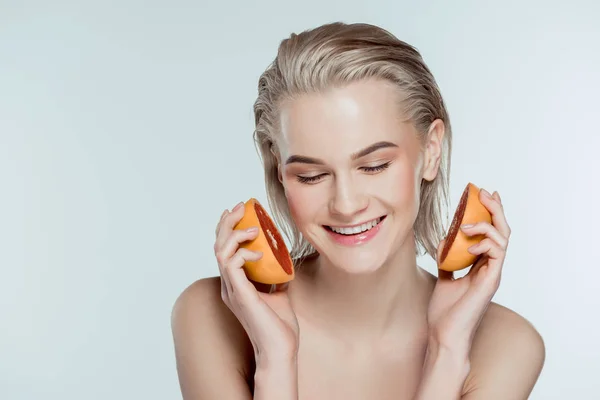 Happy beautiful girl posing with grapefruit, isolated on grey — Stock Photo