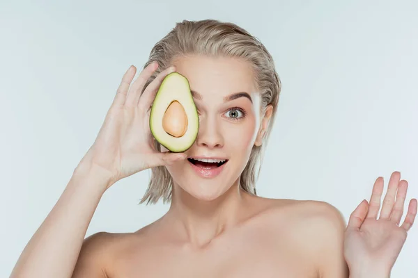Aufgeregtes schönes Mädchen posiert mit Avocado, isoliert auf grau — Stockfoto