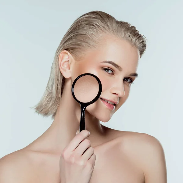 Beautiful girl with magnifier, skin care concept, isolated on grey — Stock Photo