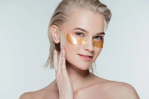 Chica atractiva con parches de ojos dorados, aislado en gris - foto de stock