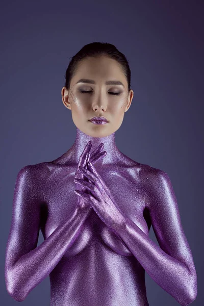 Beautiful asian girl posing in ultra violet glitter, isolated on purple — Stock Photo