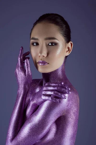 Tender fashionable asian girl in ultra violet glitter, isolated on purple — Stock Photo