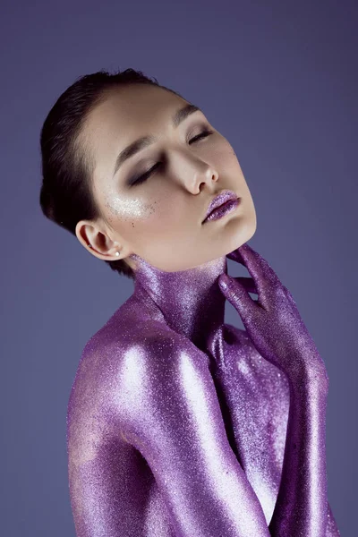 Fashionable sensual asian girl in ultra violet glitter, isolated on purple — Stock Photo