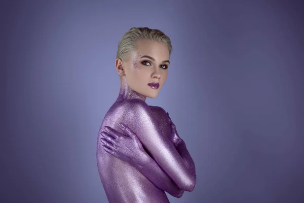 Обнаженная модная молодая женщина позирует в фиолетовом блеске, изолированная на фиолетовом — стоковое фото