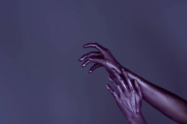 Cropped view of tender hands in purple glitter, isolated on violet — Stock Photo