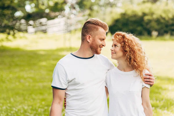 Couple heureux embrassant et se souriant au parc — Photo de stock