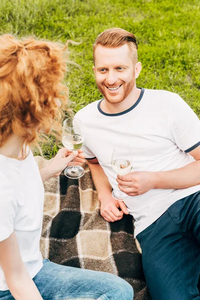 Visão de alto ângulo de casal feliz rdhead beber vinho no piquenique no parque — Fotografia de Stock