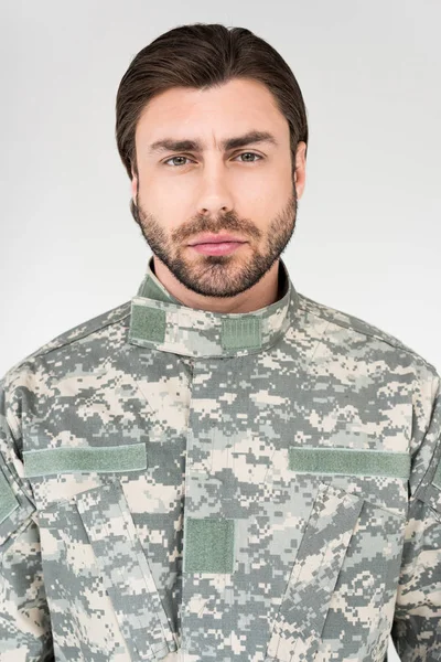 Retrato de soldado barbudo confiado en uniforme militar mirando a la cámara aislada en gris - foto de stock