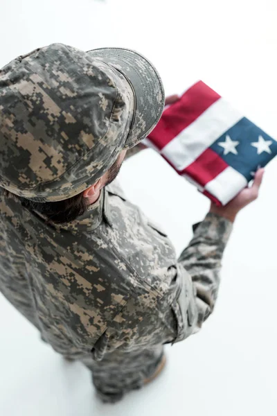 Overhead view of male soldier in military uniform with american flag in hands — Stock Photo