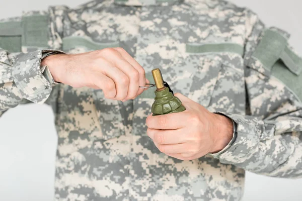 Cropped shot of soldier holding grenade in hands isolated on grey — Stock Photo