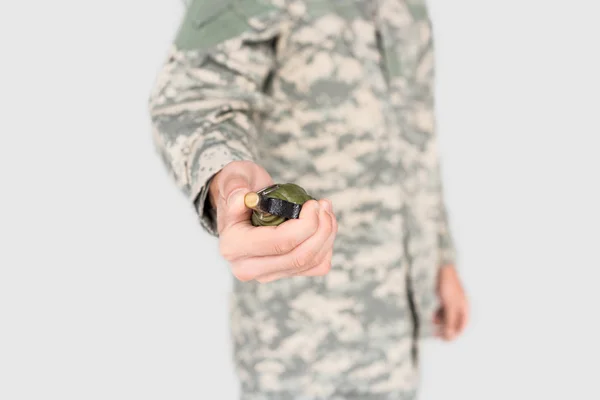 Обрізаний знімок солдата, який тримає гранату в руці ізольовано на сірому — стокове фото