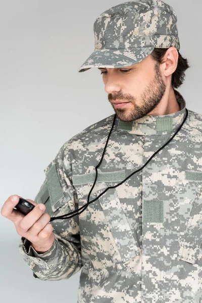 Portrait of soldier in military uniform with stop watch on grey backdrop — Stock Photo