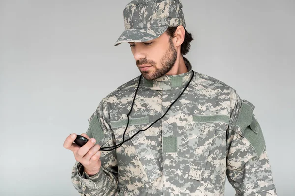 Портрет солдата у військовій формі зі стоп-годинником ізольовано на сірому — стокове фото