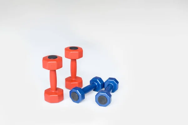 Close up view of red and blue dumbbells on grey background — Stock Photo