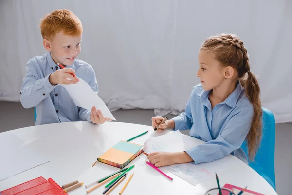 Retrato de pré-escolares bonitos desenho de imagens à mesa com em sala de aula — Fotografia de Stock