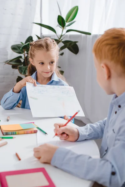 Messa a fuoco selettiva di adorabili bambini che disegnano immagini a tavola in classe — Foto stock