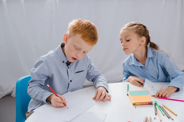 Retrato de crianças adoráveis desenho de imagens à mesa em sala de aula — Fotografia de Stock
