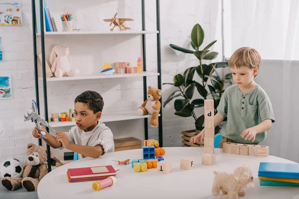 Meninos multiculturais brincando com brinquedos em sala de aula — Fotografia de Stock