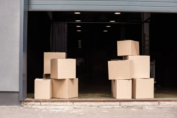 Cardboard boxes on each other near open garage — Stock Photo