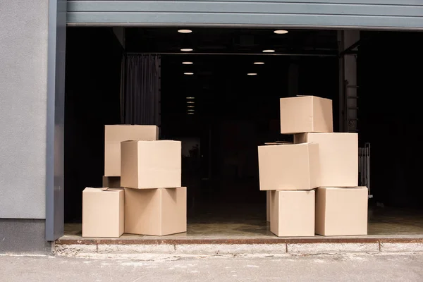 Boîtes en carton l'un sur l'autre près du garage ouvert — Photo de stock