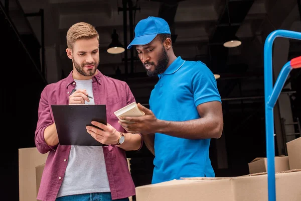 Mensajero afroamericano contando el costo de entrega - foto de stock