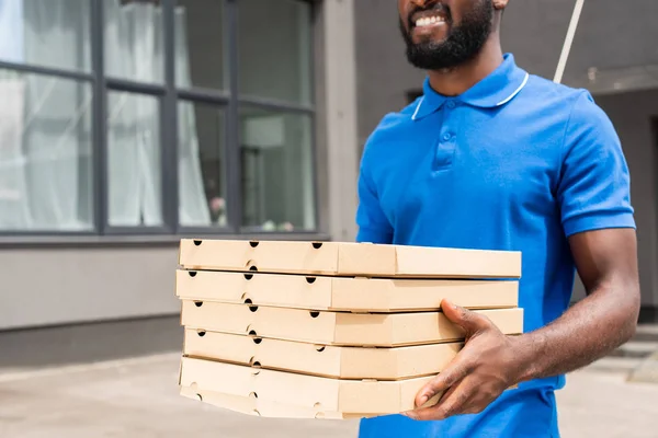 Image recadrée d'un livreur afro-américain portant des boîtes à pizza — Photo de stock