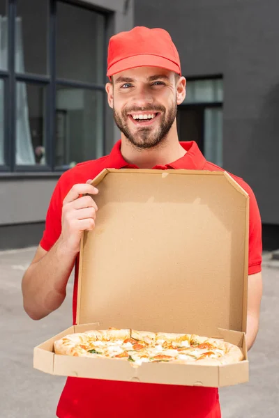 Souriant caucasien livreur tenant boîte avec pizza — Photo de stock