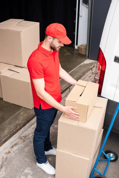 Vista de ángulo alto del joven repartidor hombre descarga cajas de cartón de van - foto de stock