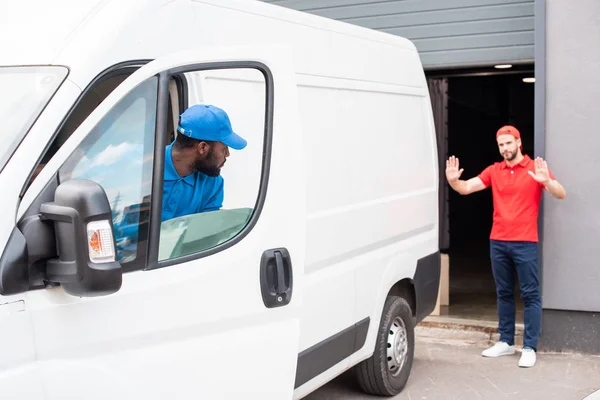 Consegna multietnica uomini in uniforme parcheggio furgone bianco sulla strada — Foto stock