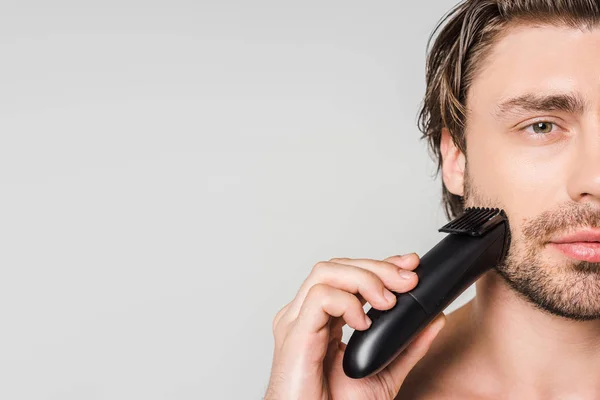 Частковий вид кавказького чоловіка з електричним затискачем бороди для гоління ізольовані на сірому — стокове фото