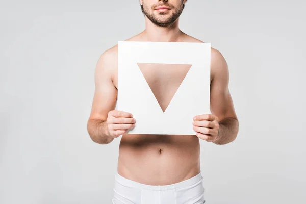 Cropped shot of man in underwear holding white paper triangle figure isolated on grey — Stock Photo