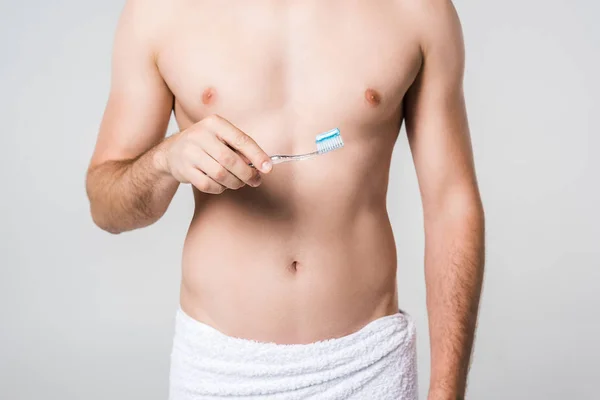 Cropped shot of man in white towel with tooth brush isolated on grey — Stock Photo