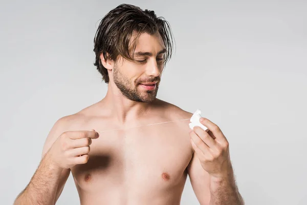 Portrait of shirtless man with dental floss isolated on grey — Stock Photo