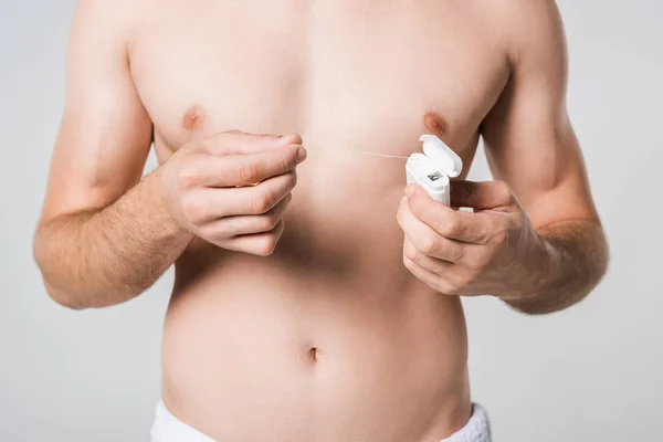 Partial view of shirtless man with dental floss isolated on grey — Stock Photo