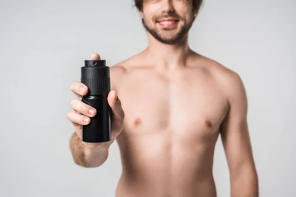 Selective focus of shirtless man with male deodorant isolated on grey — Stock Photo