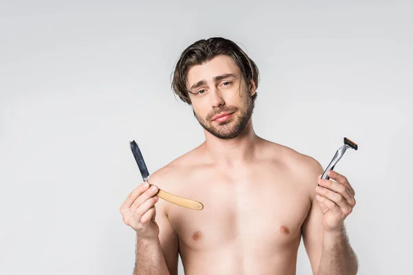 Retrato de homem sem camisa com navalhas nas mãos olhando para câmera isolada em cinza — Fotografia de Stock