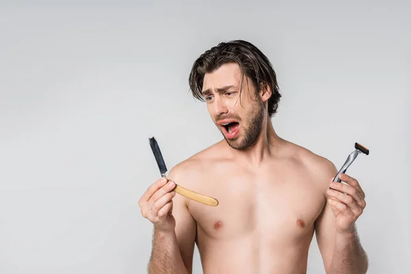 Retrato de homem sem camisa emocional com lâminas de barbear em mãos isoladas em cinza — Fotografia de Stock