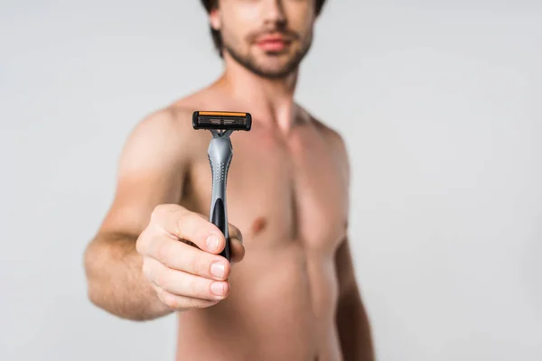 Selective focus of shirtless man with razor in hand isolated on grey — Stock Photo