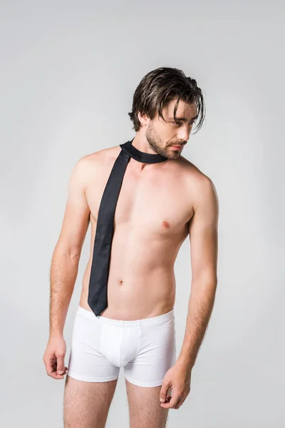 Portrait de bel homme en sous-vêtements blancs avec cravate noire sur fond gris — Photo de stock