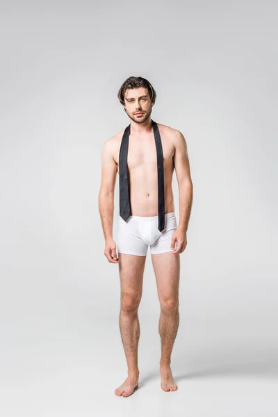 Handsome man in white underwear with black tie on grey backdrop — Stock Photo